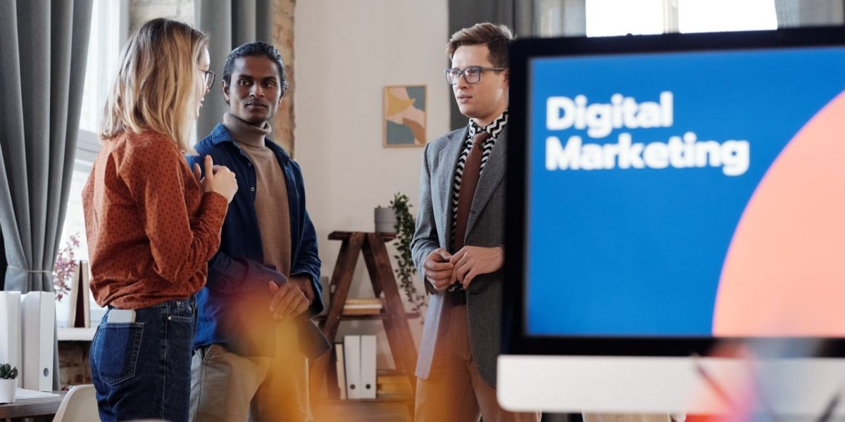 Group of colleagues discussing digital marketing strategies in an office setting.
